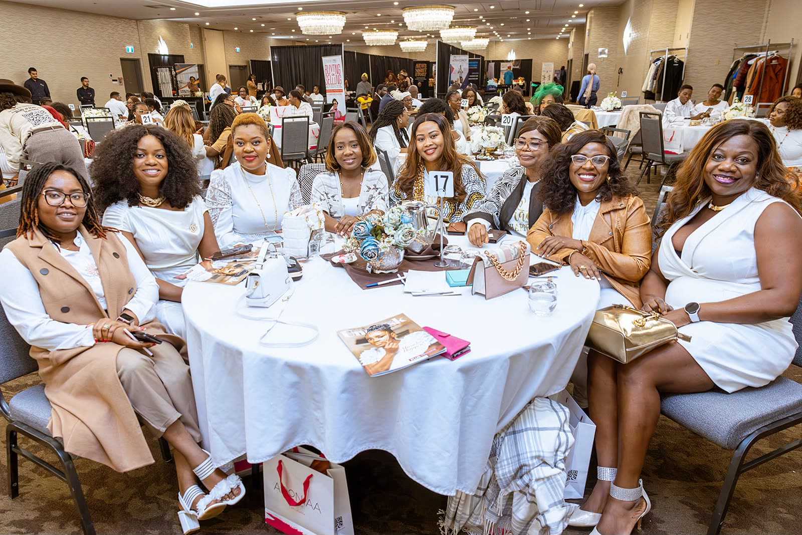 Women smiling together around a table at a UYB community event